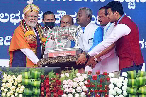 Chief Minister Basavaraj Bommai felicates PM Narendra Modi during the launch of various projects at Kommaghatta in Bengaluru. (Photo | Vinod Kumar T)