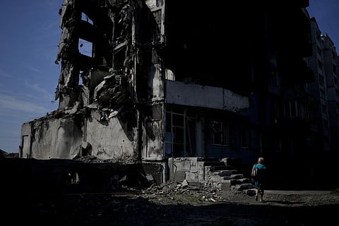 A woman walks past a building destroyed in Russian shelling in Borodyanka, on the outskirts of Kyiv, Ukraine, Tuesday, June 21, 2022.  (Photo | AP)