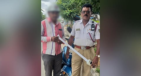 Traffic sub-inspector M Shivanna with a traffic violator 