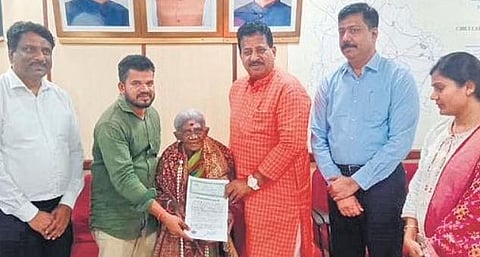 Yelahanka MLA S R Vishwanath hands over the sale deed to Thimmakka