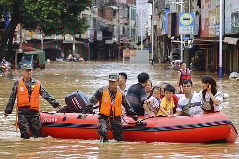 rescuers evacuate stranded residents in flood water in central China's Hunan province. (Photo | AP)