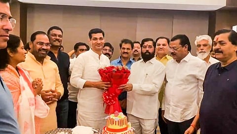 Rebel Shiv Sena leader Eknath Shinde presents a bouquet to a supporting MLA during the latter's birthday celebration, at Radisson Blu Hotel in Guwahati. (Photo | PTI)