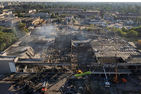 Ukrainian State Emergency Service firefighters work to take away debris at a shopping center burned after a rocket attack in Kremenchuk, Ukraine, on Tuesday. (Photo | AP)