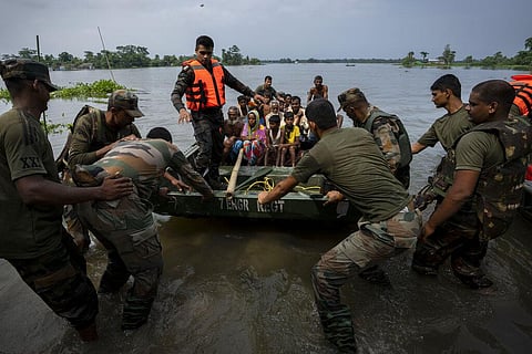 Indian army personnel rescue flood-affected villagers on a boat in Tarabari village, west of Guwahati. (Photo | AP)