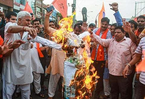 Members of Vishva Hindu Parishad (VHP) and Bajrang Dal burn an effigy during a protest against the killing of tailor Kanhaiya Lal in Udaipur. (Photo | PTI)