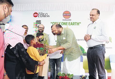 Min of Industries, Coir and Law P Rajeeve distributes tree saplings at TNIE-IOC environment day function. IOC’s Division Retail Sales Head (Cochin Div Off) Vipin Austin (R) looks on. (Photo | EPS)