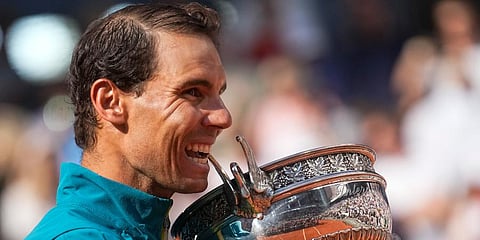 Rafael Nadal bites the trophy after winning the final match against Casper Ruud in three sets, 6-3, 6-3, 6-0, at the French Open tennis tournament in Roland Garros Stadium in Paris. (Photo | AP)