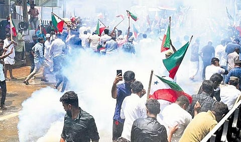 PFI activists run away after the police burst tear gas during a protest march at Devaswom Board junction in Thiruvananthapuram on Monday | Vincent Pulickal