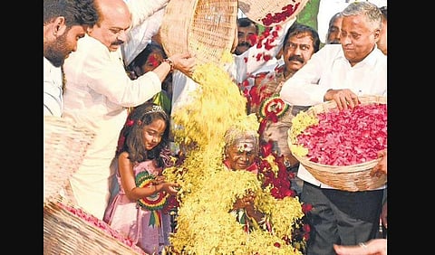CM Basavaraj Bommai covers Padma Shri Saalumarada Thimmakka in flower petals on her 111th birthday at Ambedkar Bhavan, in Bengaluru | Nagaraja Gadekal