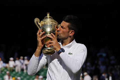 Serbia's Novak Djokovic celebrates with the trophy after beating Australia's Nick Kyrgios in the final of the men's singles on day fourteen of the Wimbledon. (Photo | AP)