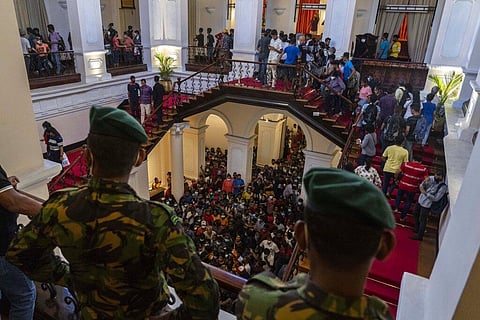 Army officers stand guard as people throng President Gotabaya Rajapaksa’s official residence for the second day after it was stormed in Colombo. (Photo | AP)