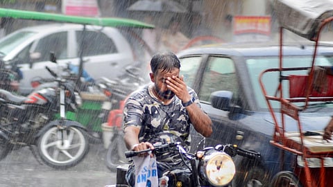 A man rides a motorcycle amid monsoon rain in Amritsar.