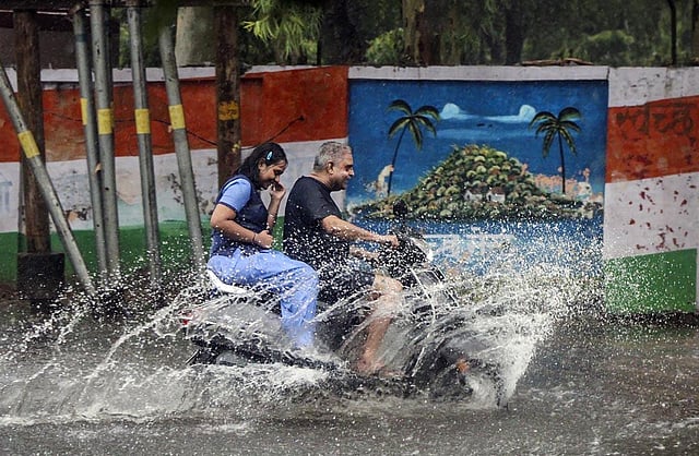 Commuters pass through a waterlogged road after heavy monsoon rains, in Meerut. According to the IMD, thunderstorms and light precipitation is anticipated in the city on July 13, with the maximum temperature of 33 degree celsius and minimum of 28 degree celsius (Photo | PTI)