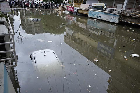 Vehicles seen submerged at a water logged shopping complex after heavy rain lashed city on Sunday night in Ahmedabad. A total of 64 people have died in Gujarat due to various rain related incidents.