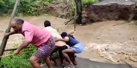 Locals rescue Manickam by throwing ropes and crawl up the broken bridge in Nilgiris. (Photo| EPS)