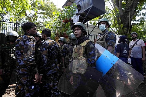Sri Lankan army soldiers watch as protesters storm the compound of prime minister Ranil Wickremesinghe 's office, demanding he resign. (Photo | AP)