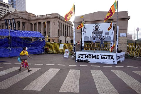 A woman walks past protesters blocking the entrance to presidential secretariat in Colombo, Sri Lanka, Friday, July 15, 2022. (Photo | AP)