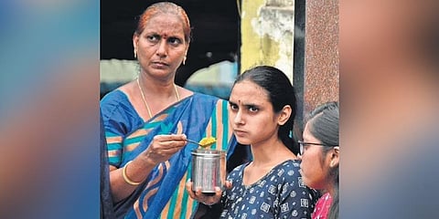 A woman feeds her daughter in front of NEET exam centre in Vijayawada on Sunday. (Photo | Prasant Madugula)