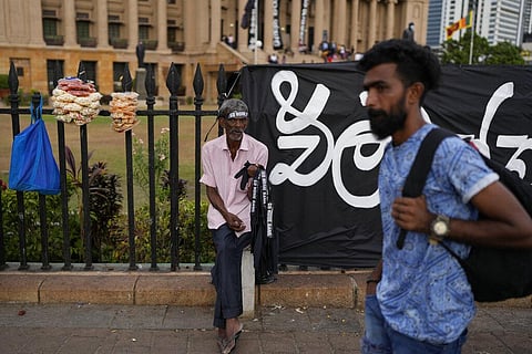 A man sells hand bands which read 'Ranil Go home' referring to Prime Minister Ranil Wickremesinghe at the protest site in Colombo, Sri Lanka. (Photo | AP)