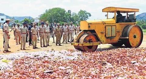 Non-Duty Paid Liquor bottles seized in SEB and police raids being destroyed in Chittoor district on Friday. (Photo | Express)