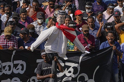 Protestors carry an effigy of acting president and Prime Minister Ranil Wickremesinghe outside the president's office as they demand his resignation in Colombo. (Photo | AP)