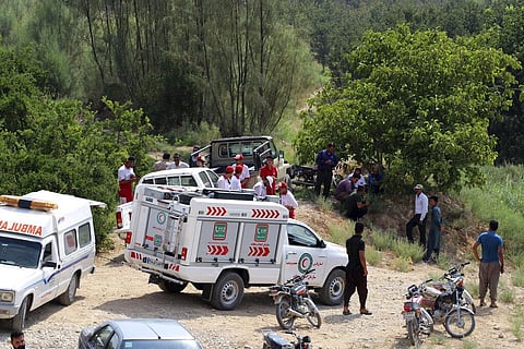 Members of rescue teams and people gather in an operation searching for missing people. (Photo | AP)