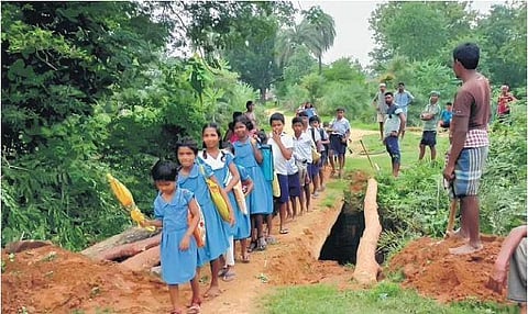Children cross the makeshift bridge as they head to school in Satjharia | Express