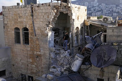 A Palestinian boy inspects the damage to a house after Palestinian gunmen were killed in an early morning Israeli military raid in the Old City of Nablus in the West Bank. (Photo | AP)