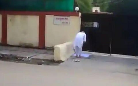 An elderly man offers namaz in front of an IAS officer's house. (Photo | Twitter)