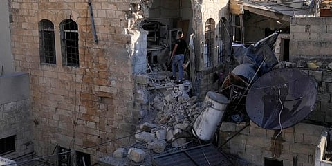 A Palestinian boy inspects the damage to a house after Palestinian gunmen were killed in an Israeli military raid in the Old City of Nablus in the West Bank. (Photo | AP)