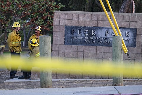 Firefighters talk to one another near the scene of a shooting at Peck Park in San Pedro, Los Angeles. (Photo |AP)