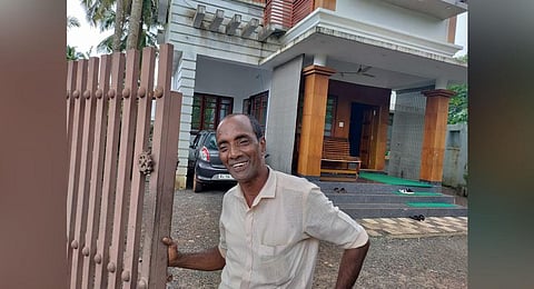 A smiling Mohammed Bava in front of his two-storey house which he almost lost.