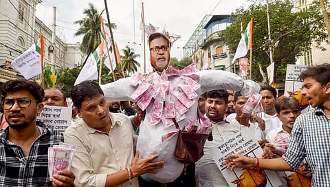 Members of Chhatra Parishad protest against West Bengal Minister Partha Chatterjee with fake currencies after he was arrested by ED officials. (Photo | PTI)