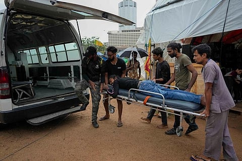 Protesters and para medics carry an injured protester into an ambulance in Colombo, Sri Lanka. (Photo | AP)