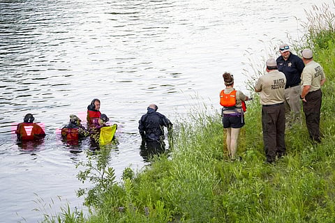 Water Recovery authorities comb the Apple River with metal detectors after five people were stabbed while tubing down the river. (Photo | AP)