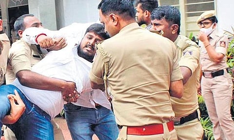 Policemen detain an ABVP member who barged into Home Minister Araga Jnanendra’s residence, in Bengaluru on Saturday | Express
