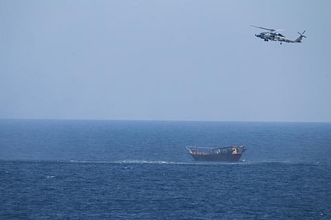 A U.S. Navy Seahawk helicopter flies over a stateless dhow later found to be carrying a hidden arms shipment in the Arabian Sea. (Photo | AP)