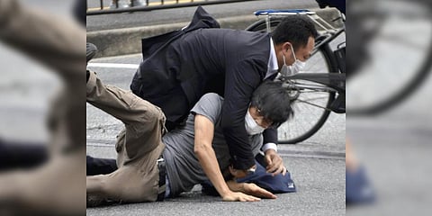 Tetsuya Yamagami,the assassin of Shinzo Abe, bottom, is detained near the site of gunshots in Nara Prefecture, western Japan.(Photo | AP)
