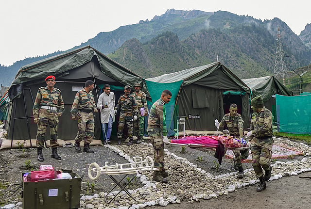 Army soldiers carry an injured pilgrim who was evacuated from the flash flood area near the Amarnath cave shrine by helicopter, at Baltal base camp in Ganderbal district of Central Kashmir, on July 9, 2022. (Photo | PTI)