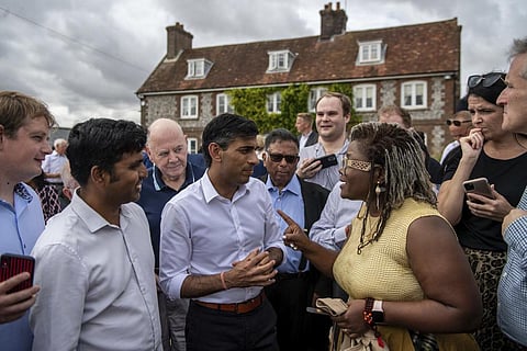 Britain's former Chancellor of the Exchequer Rishi Sunak, centre, speaks to people at an event as part of his campaign to be leader of the Conservative Party and the next prime minister, in England. (