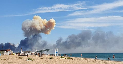 Rising smoke can be seen from the beach at Saky after explosions were heard from the direction of a Russian military airbase near Novofedorivka, Crimea. (Photo | AP)