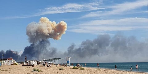Rising smoke can be seen from the beach at Saky after explosions were heard from the direction of a Russian military airbase near Novofedorivka, Crimea. (Photo | AP)