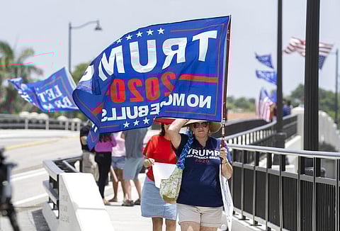 Trump supporters carry flags near Mar-a-Lago in Palm Beach, Fla., on Tuesday, August 9, 2022. (Photo | AP)