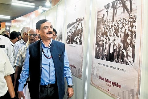 DMRC MD Vikas Kumar takes a look through photographs at the event. (Photo | Parveen Negi, EPS)