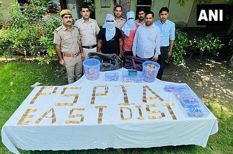 Police officials with the sezied cartridges and six people who were arrested. (Photo | ANI Twitter)