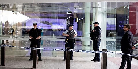 Police stand guard at the entrance of a terminal after a gunman opened fire at the airport in Canberra. (Photo | AFP)
