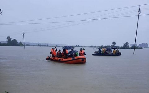 Personnel of ODRAF rescuing flood-hit people at Athamallick area of Angul district on August 14. (Photo | Twitter/@osdmaodisha)