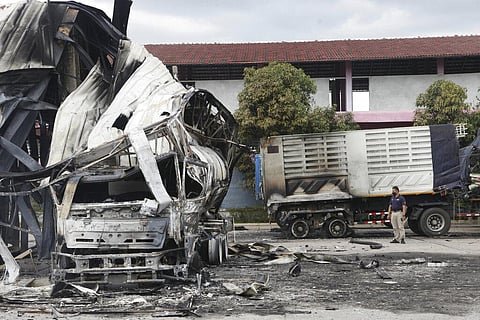 A Thai officer stands beside the burnt down oil tanker at a gas station in Pattani province, southern Thailand, Wednesday, Aug. 17, 2022.(Photo | AP)