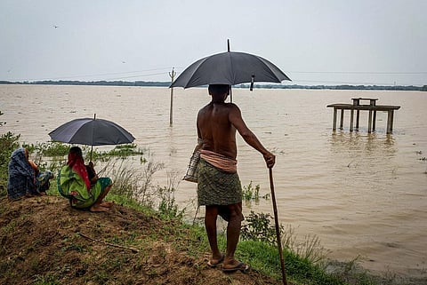 Villagers watch overflowing Mahanadi river in Jagatsinghpur. (Photo | Debadatta Mallick, EPS)