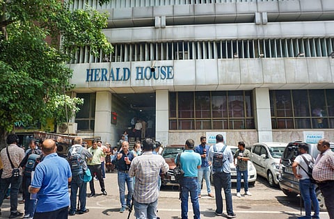 Media personnel gather outside the head office of Congress-owned National Herald newspaper amid a raid by ED officials as part of an ongoing money laundering probe, in New Delhi. (Photo | PTI)